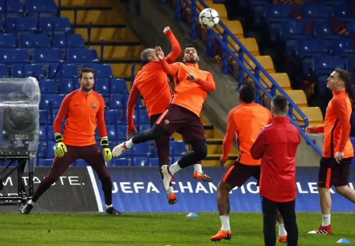 Luis Suárez salta por el balón ante Andrés Iniesta, durante los entrenamientos del Barcelona. /Foto AP