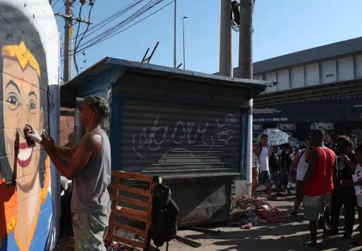 Un hombre pinta un grafiti del rostro de Marielle Franco en la favela carioca de Maré. EFE