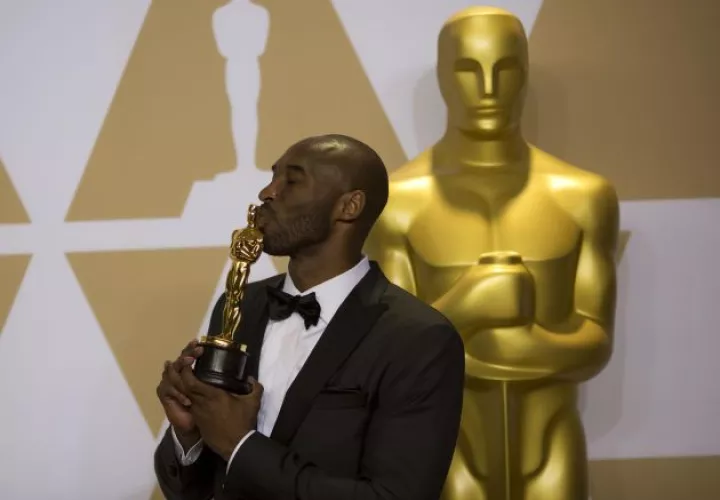 Kobe Bryant con su estatua de los Oscar. Foto AP