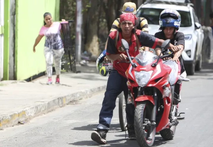Los saqueadores se van con una motocicleta que acaban de sacar de una tienda en Managua. AP