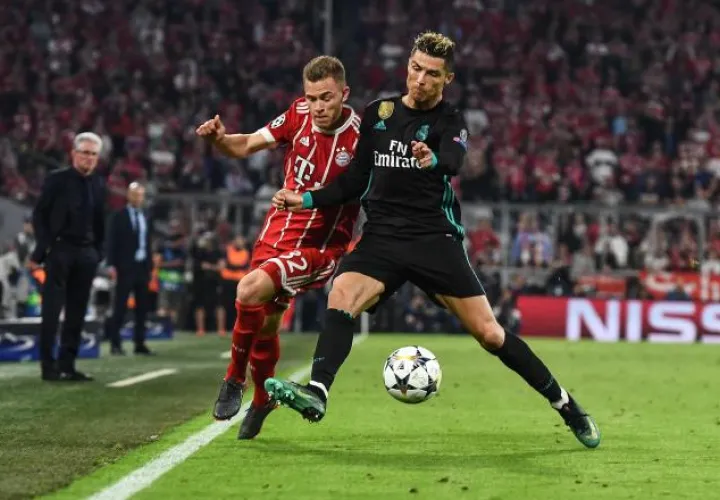 Joshua Kimmich (izq.), de Bayern, disputa un balón con Cristiano Ronaldo de Real Madrid. EFE