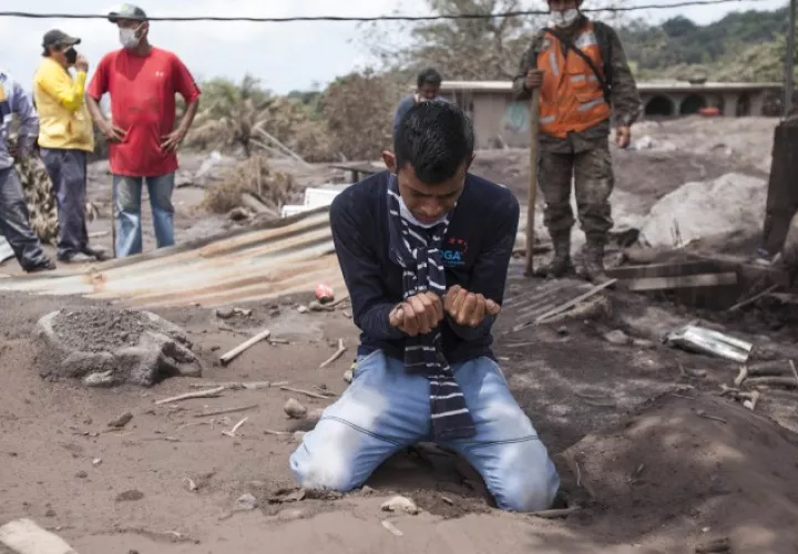Bryan Rivera llora en medio del lugar que era su casa y donde perdió a sus familiares debido a la erupción del volcán. AP