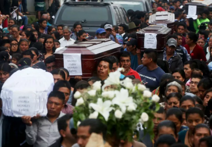 Cientos de personas acompañan los féretros de siete de las víctimas. Foto: EFE 