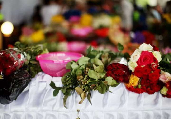 Primer plano de un arreglo floral sobre uno de los ataúdes de una víctima de la erupción del Volcán de Fuego. FOTO/EFE