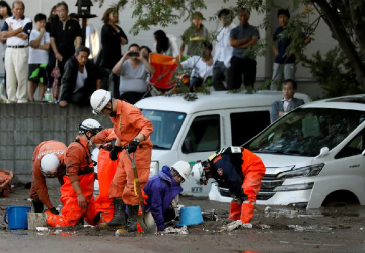Una trabajadora de HTB (2-d) es rescatada por los servicios de emergencias tras verse atrapada en el lodo por el terremoto en Japón. EFE