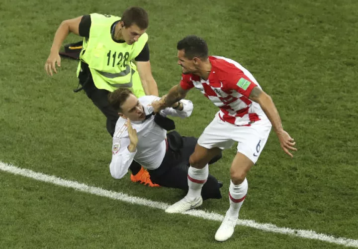 Pyotr Verzilov (cent.) en la final del mundial de Rusia es atrapado por un seguridad. Foto:AP 