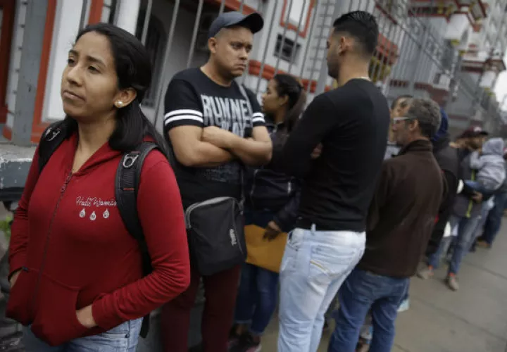 Migrantes venezolanos afuera de la embajada de su país en Lima, Perú. Foto: AP.