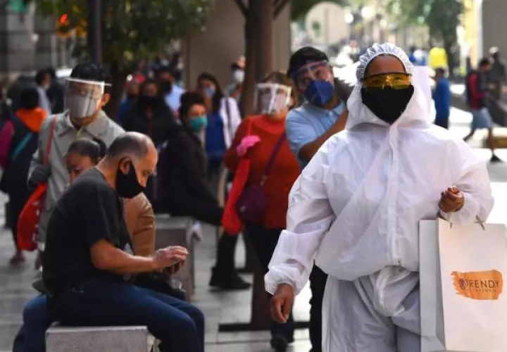 Un transeúnte viste un traje de alta seguridad sanitaria durante sus compras en el Centro histórico de Ciudad de México. 