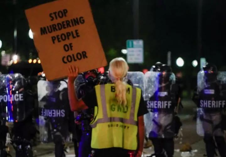 Una manifestante confronta a la Policía en Kenosha (EE.UU.), en la continuación de las protestas por el ataque policial contra Jacob Blake. Fotos. EFE.