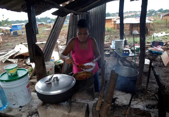 Yeisi Rodríguez, de 47 años, cocina en una casa improvisada en el terreno "Victoriano Lorenzo". Foto: EFE