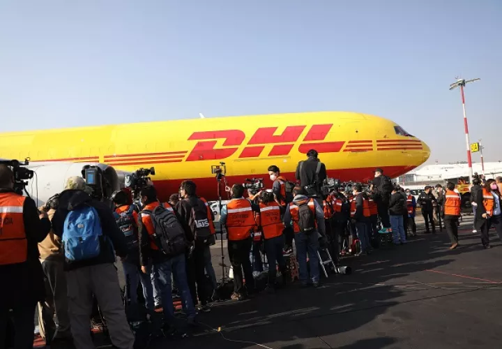 Periodistas observando el desembarque con las primeras vacunas contra la COVID-19, procedentes de Bélgica, al aeropuerto Internacional de La Ciudad de México. Foto: EFE