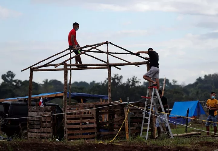 Un hombre construye una casa improvisada en el terreno "Victoriano Lorenzo". Foto: EFE