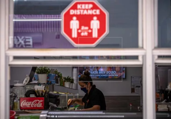 Una mujer trabaja en un local de comida que solo sirve por ventana, debido a la pandemia del coronavirus, en Miami, Florida. Foto: EFE