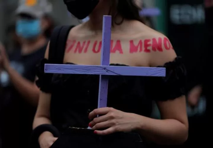 Una mujer marcha con una cruz durante una manifestación con motivo del Día Internacional de la Eliminación de la Violencia contra las Mujeres. EFE