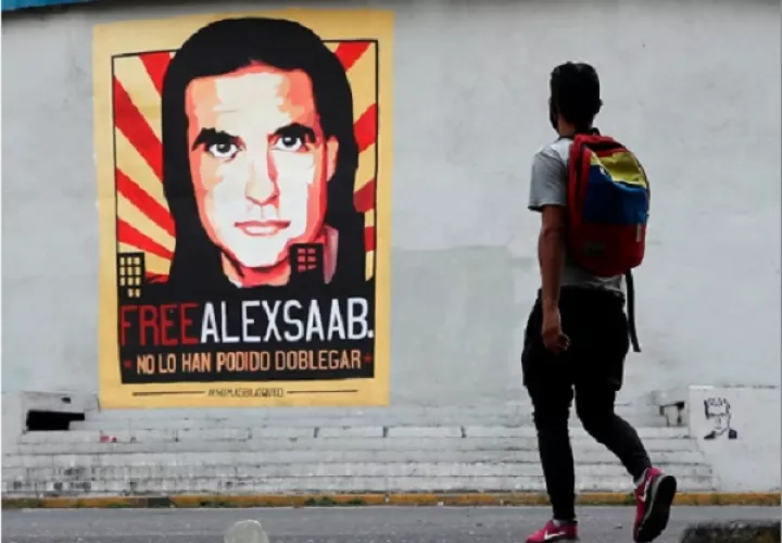Un hombre pasa frente a un cartel de apoyo al empresario colombo-venezolano Alex Saab, en Caracas (Venezuela). Foto: EFE