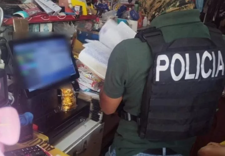 Policía revisa el material encontrado en un comercio, donde se detuvo a un comerciante relacionado con este hecho. Foto: Cortesía Policía Nacional