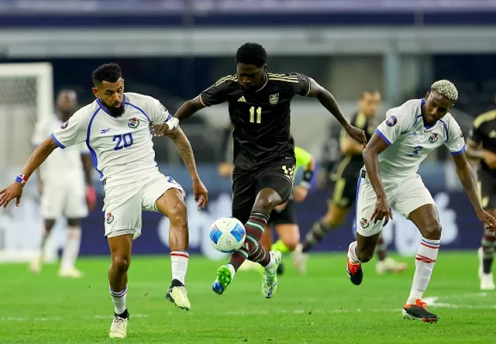 Aníbal Godoy (izq) y José Córdoba (2) de Panamá marcan a Shamar Nicholson de Jamaica (11). Foto: EFE