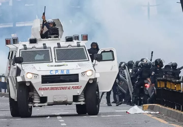 Integrantes de la Policía Nacional Bolivariana (PNB) enfrentan a manifestantes opositores. Foto: EFE