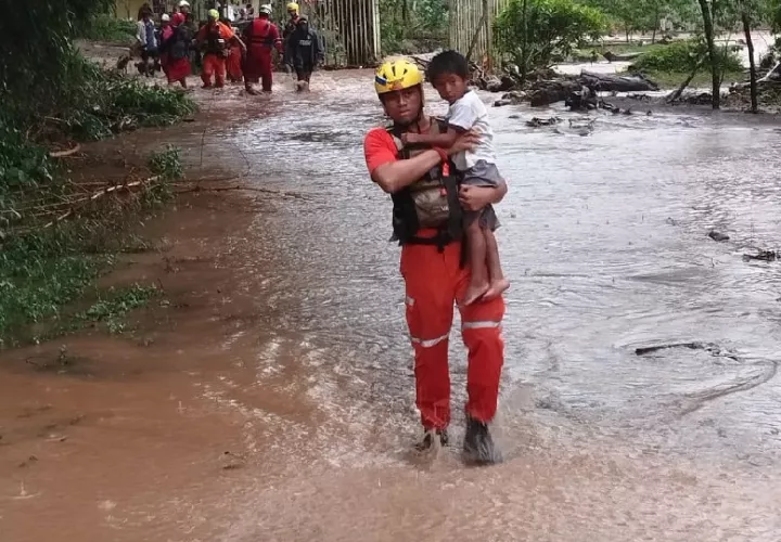 Personal de Sinaproc ayuda a un grupo de personas a salir de un área inundable. Foto. Sinaproc