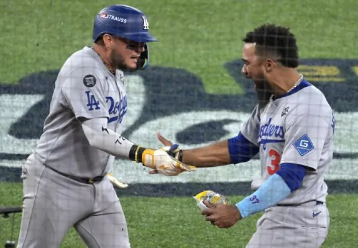 Miguel Rojas (izq.) es felicitado por Teoscar Hernández por su jonrón ante los Azulejos en el séptimo partido de la Serie Mundial. Foto: EFE