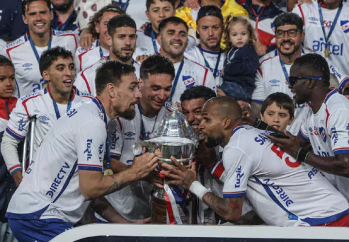 Luis 'Manotas' Mejìa (der.) levanta el trofeo de campeón en Uruguay.. Foto: EFE