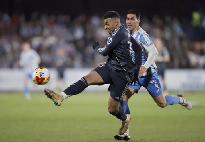 El delantero francés del Real Madrid, Kylian Mbappé, patea el balón ante el jugador del Talavera, Álvaro López. Foto: EFE