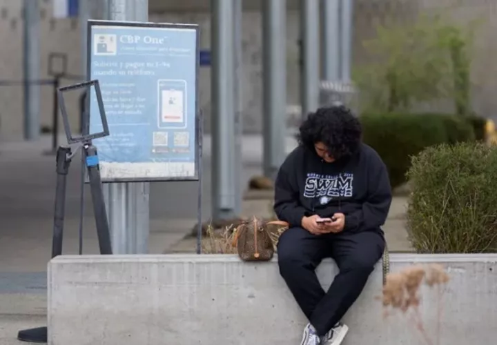 Una persona ingresa desde su teléfono móvil a la aplicación CBP One, desde donde los migrantes pueden tramitar su autodeportación en Estados Unidos. Foto: EFE