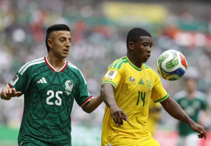 Roberto Alvarado (i) de México disputa un balón con Mbekezeli Mbokazi de Sudáfrica este jueves, durante un partido del Grupo A. Foto: EFE