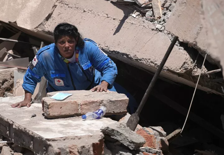Una integrante de la Cruz Roja de Colombia busca entre los escombros de una edificación colapsada. Foto: EFE