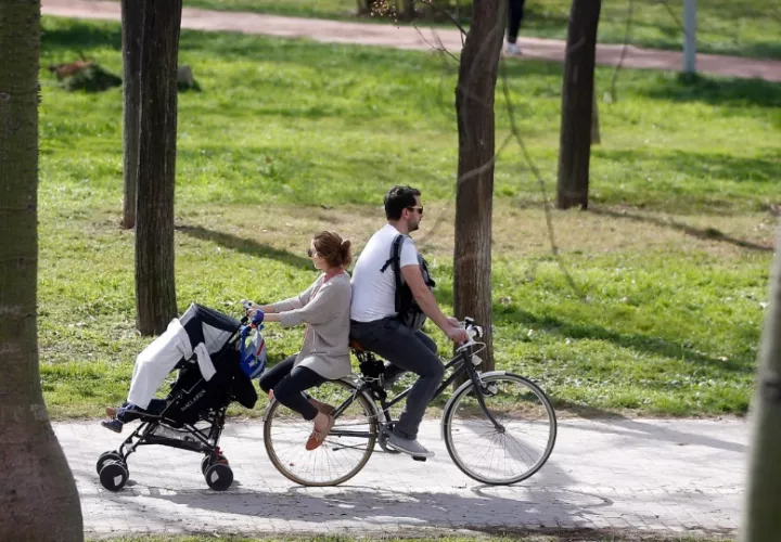 Una pareja pasea en bicicleta con el carrito de bebe a remolque.  Foto: EFE / Kai Försterling