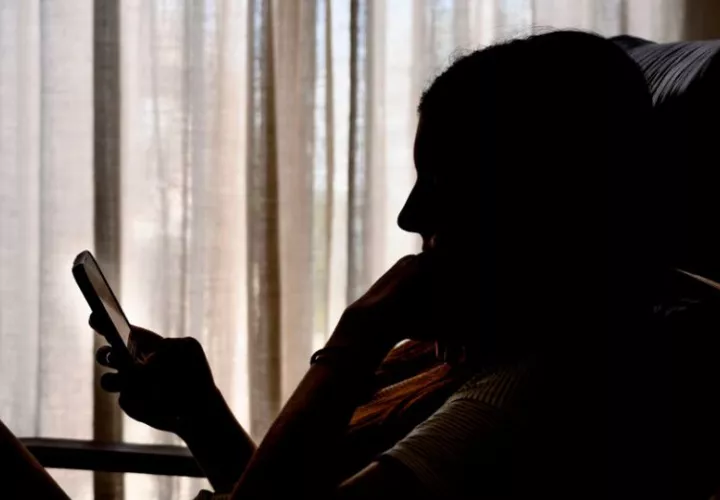 Una adolescente consulta una red social en su móvil. Foto. EFE