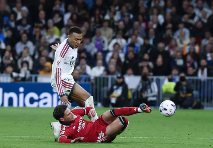 El delantero francés del Real Madrid Kylian Mbappé (arriba) lucha por el balón con José Carmona, del Sevilla. Foto: EFE 