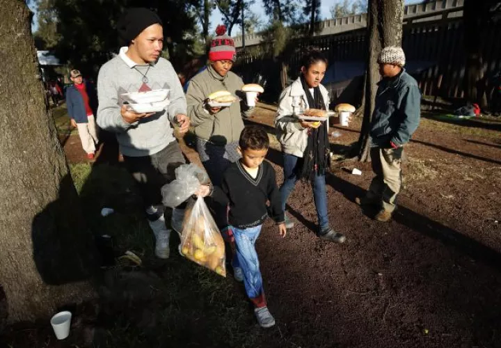 Migrantes reciben comida en el deportivo Jesús Martínez Palillo, en Ciudad de México. EFE