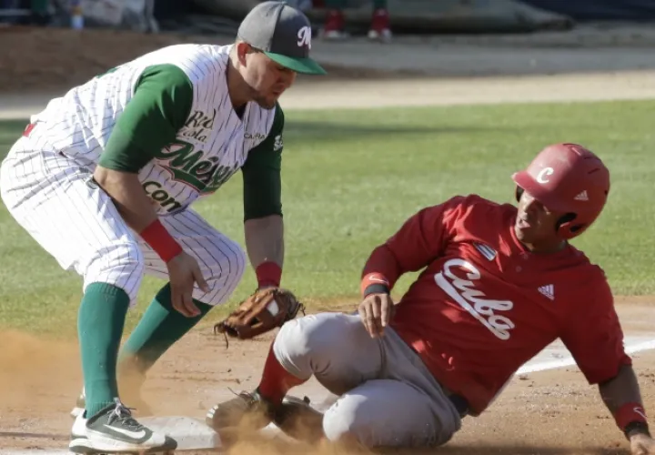 Jorge Aloma, de Cuba, llega a salvo a la tercera base que cubre el mexicano Agustín Murillo. AP