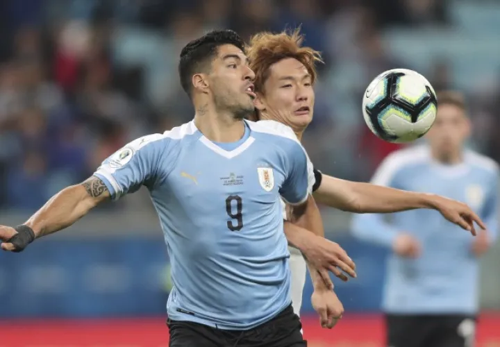 Luis Suárez disputa el balón ante Kou Itakura, de Japón. AP