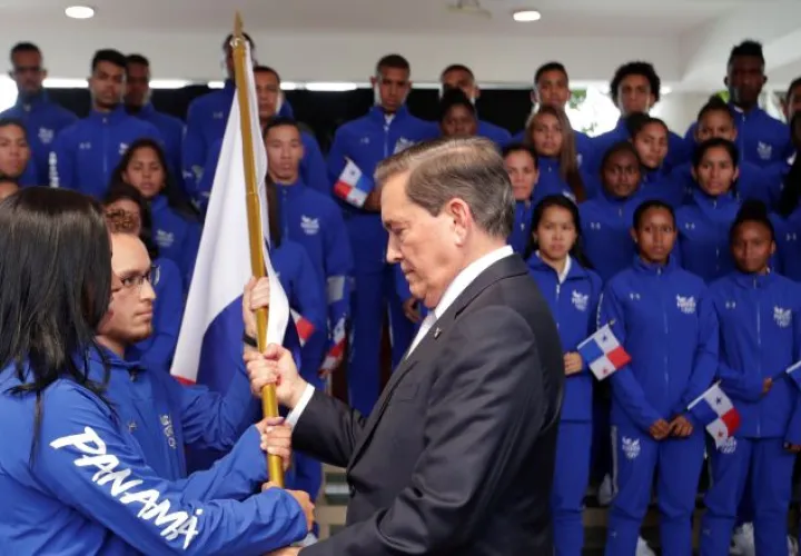 Kristine Jiménez y Héctor Cención recibieron ayer el pabellón de manos del presidente Laurentino Cortizo. EFE
