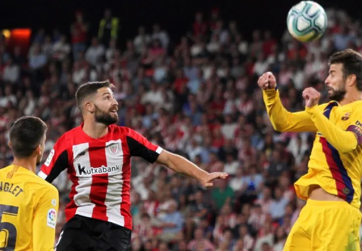 Gerard Piqué del Barcelona (der.) salta por el balón.