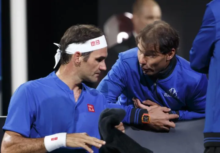 Federer (izq.) habla con Nadal. AP
