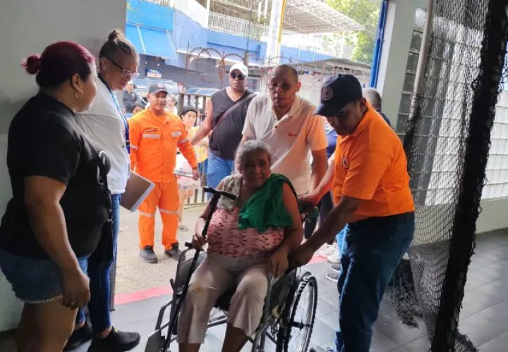Personal del Sinaproc brinda asistencia a una mujer con movilidad reducida. Cortesía