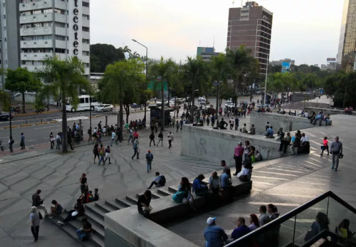 Cientos de personas caminan este jueves por una calle de Caracas (Venezuela), luego de un apagón eléctrico que afectó a gran parte del país. Foto: EFE.