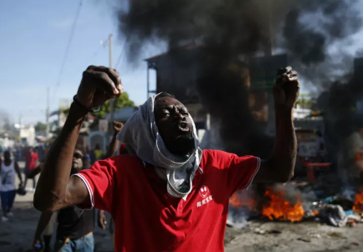 Guardias presidenciales custodian un convoy que transporta al presidente Jovenel Moise. Foto. AP.