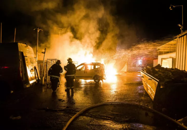 Bomberos israelíes sofocan el fuego de un auto bombardeado por Hamas. Foto: AP.