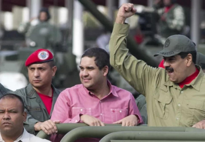 Nicolas Maduro Jr., centro, acompaña a su padre, Nicolás Maduro en una parada militar en Caracas, el 13 de abril de 2018. Foto: AP.  