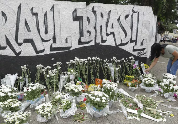 Una mujer coloca flores como tributo a las víctimas de la matanza en Suzano, Brasil. Foto: AP. 