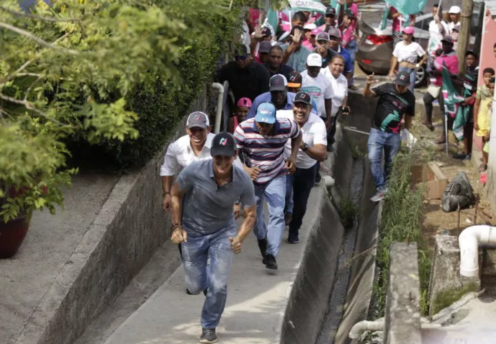 Rómulo Roux durante su recorrido puerta a puerta en los hogares en el sector de Cerro Batea, junto a su compañero de fórmula Luis Casís.