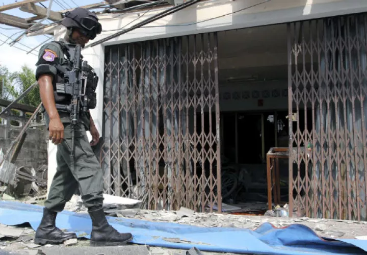 Un agente de la policía fronteriza inspecciona el lugar donde ha estallado una bomba en una peluquería. Foto: EFE