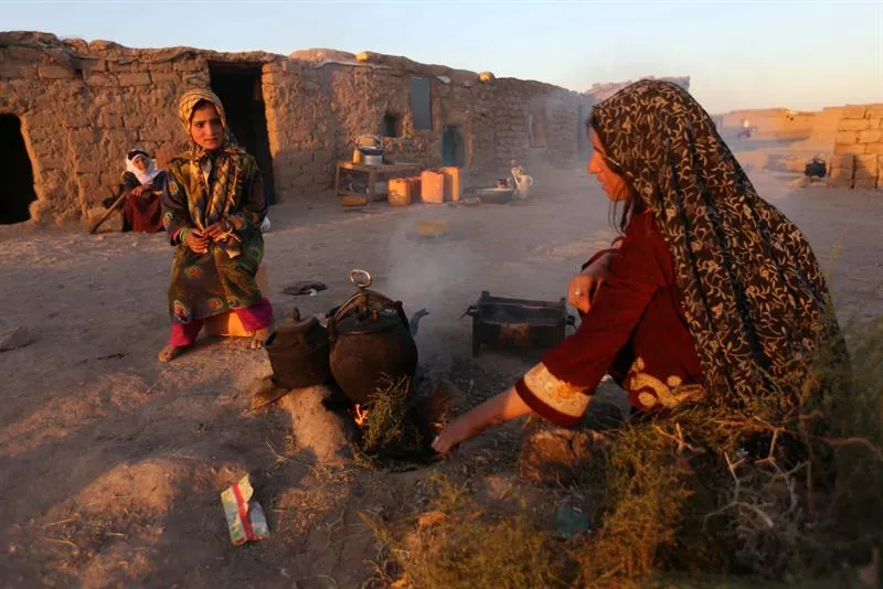Dos mujeres afganas de la provincia de Faryab cocinan en un campo de refugiados a las afueras de Herat (Afganistán). EFE