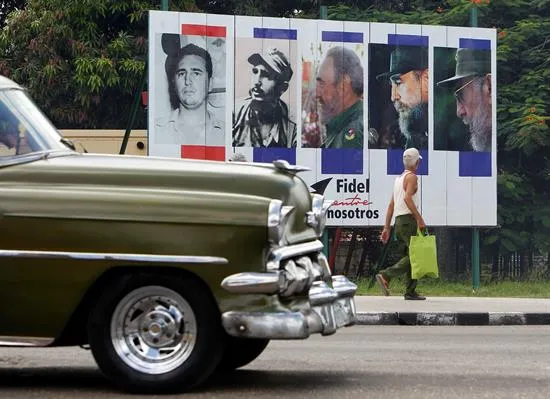 Un vehículo pasa junto a un cartel alusivo al cumpleaños 90 del líder de la revolución cubana Fidel Castro este sábado 13 de agosto. Foto: EFE