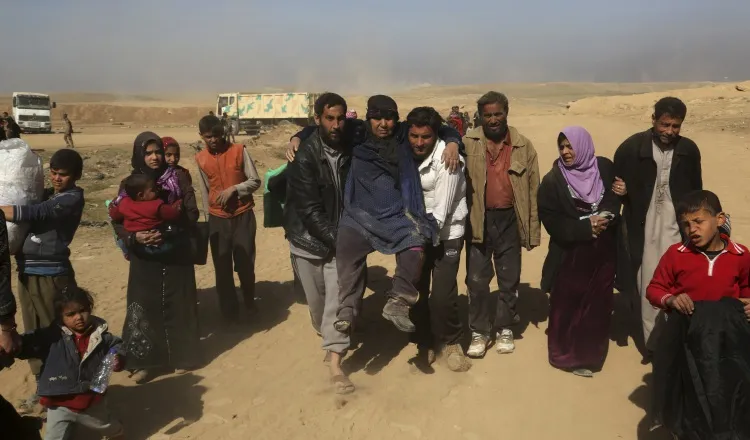 Familias iraquíes abandonan sus casas ante el recrudecimiento de los enfrentamientos armados. AP