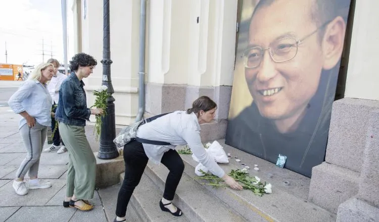 Colocan flores frente a una imagen de Liu Xiabo, fuera del Centro Nobel de la Paz en Oslo, Noruega. /Foto EFE